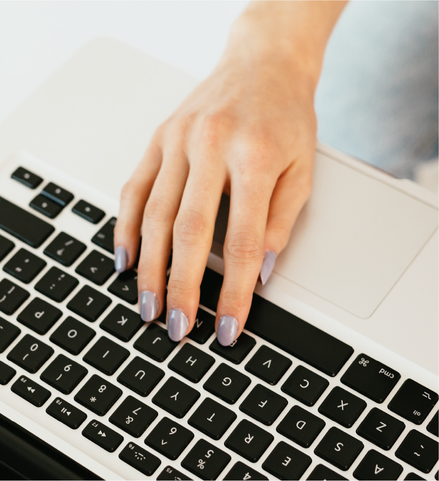 Asset 17@3x ScopeSchool A hand with light purple nail polish rests on the keyboard of a laptop.